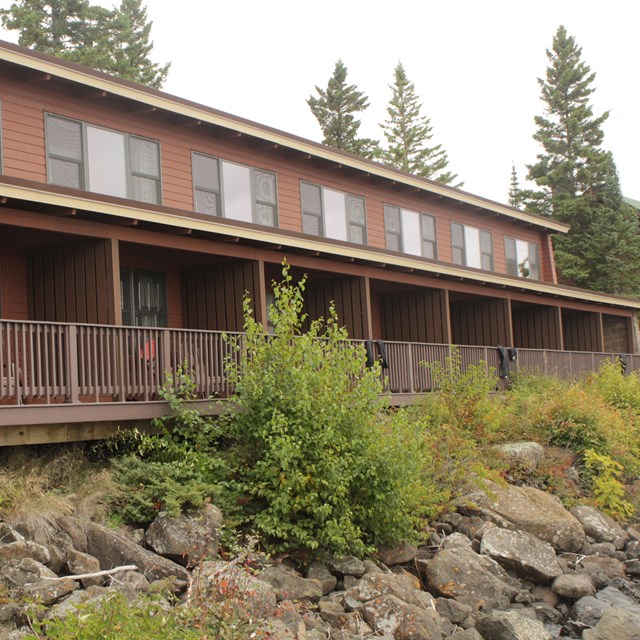 A long brown lodge building with several windows and decks