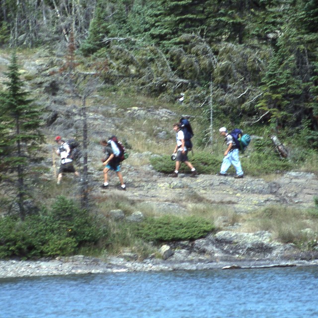 A group of campers backpacks along Rock Harbor Channel.