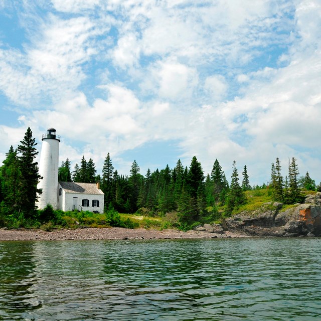 view of lighthouse from Middle Islands Passage on a blue sky day