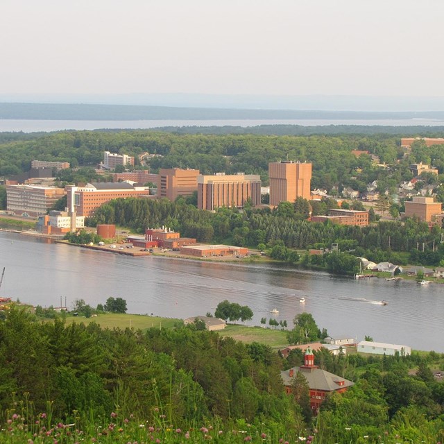 An aerial photo of a campus with a canal in the foreground