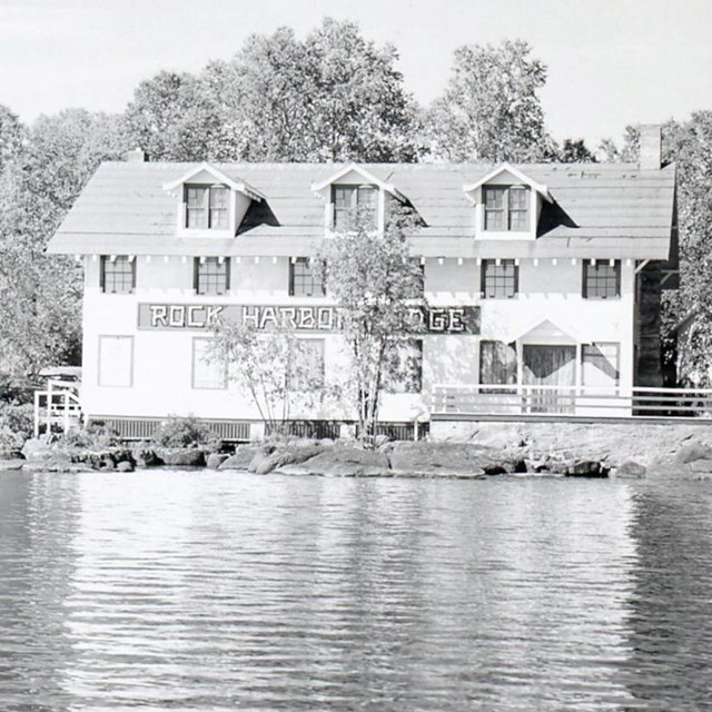 large guesthouse on waterway with name spelled in large letters on exterior