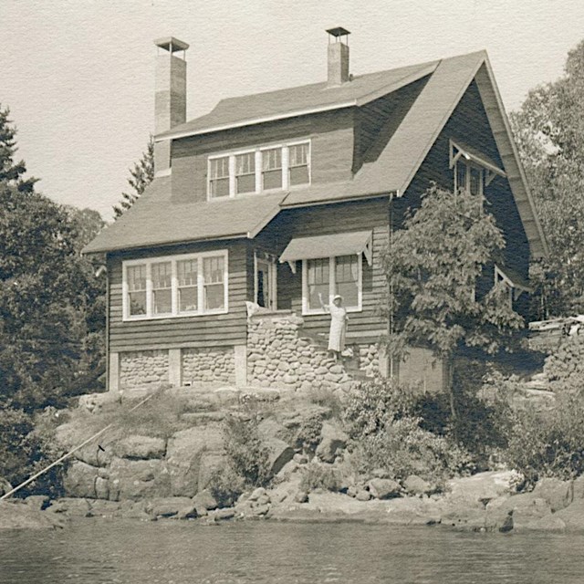 ornate two story house overlooking the Rock Harbor channel, two chimneys and 10 windows visible