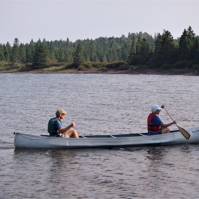 Two people sharing a canoe in the water.