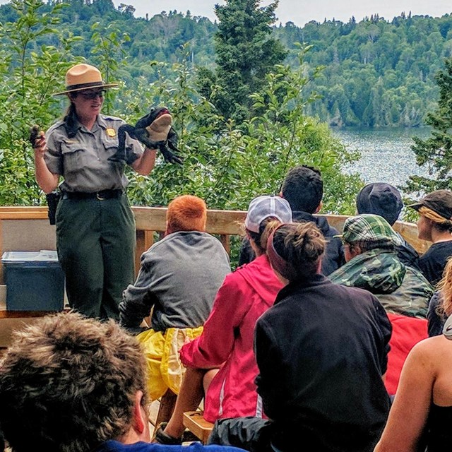 park ranger presents interpretive program to crowd of a dozen along the cold, rocky shoreline