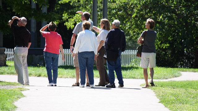 a group of visitors looking toward the house