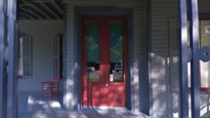 a red front door of a gray house