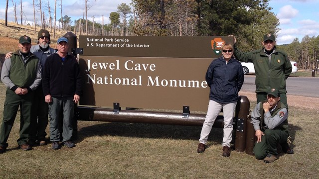 Management standing next to the entrance sign.