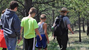 A park ranger leads a group of Junior Rangers down the Roof Trail.
