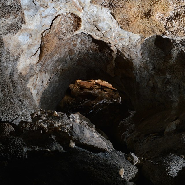 Photo of the interior of Jewel cave lit up by a small headlamp light.