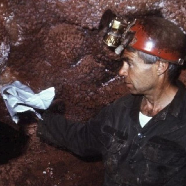 Photo of Herb Conn using a handkerchief to demonstrate the barometric wind in Jewel Cave.