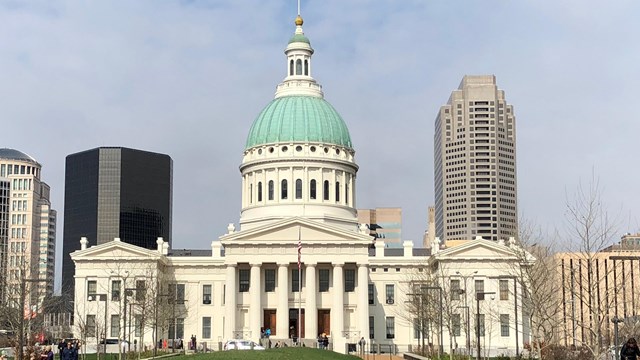 white columned building with green dome 