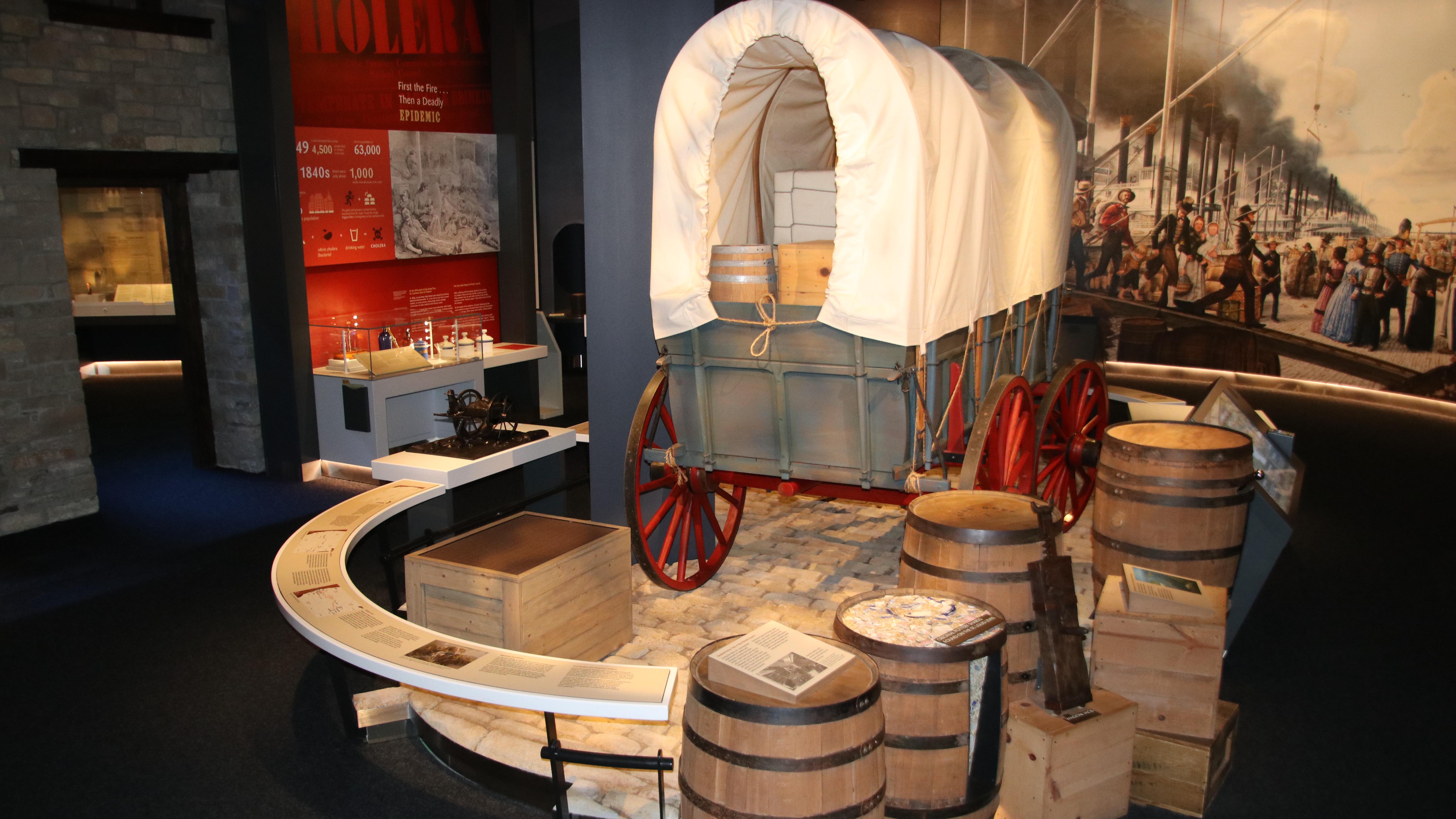 A covered wagon in a dark museum