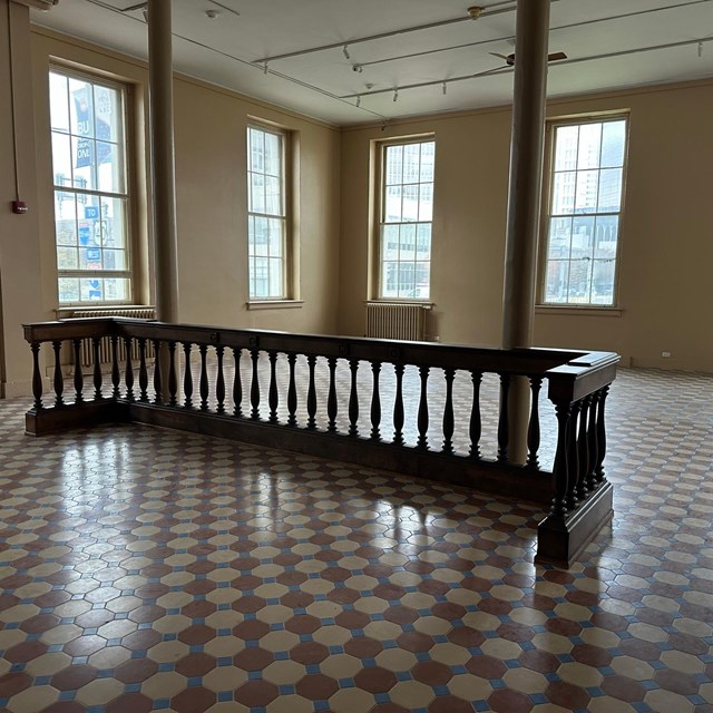 an empty courtroom with a bar and a checkered floor