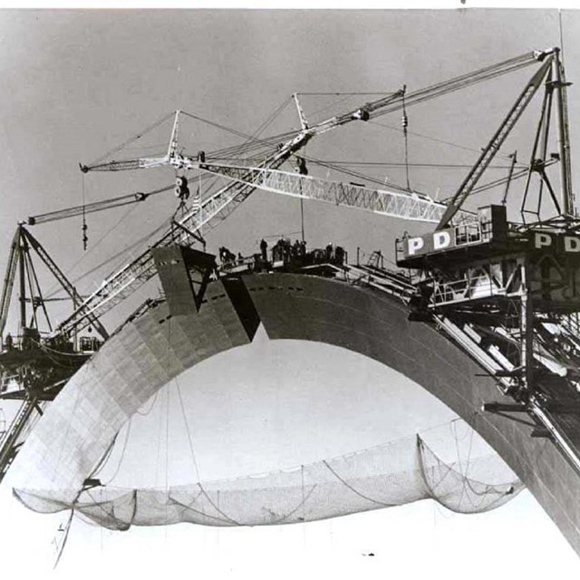 Construction workers and cranes on top of the Gateway Arch during construction in the 1960s.