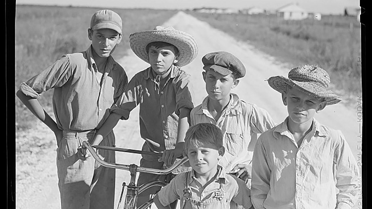 a group of children pose for a picture on a farm.