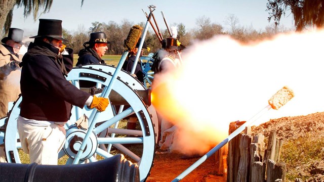 Living historians in soldier uniforms fire a canon during the 200th anniversary of the battle