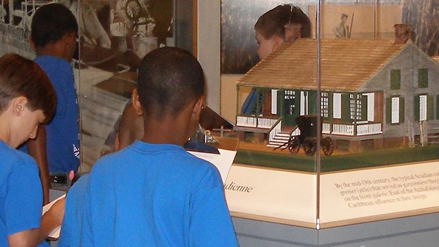 Boys looking at model of old house