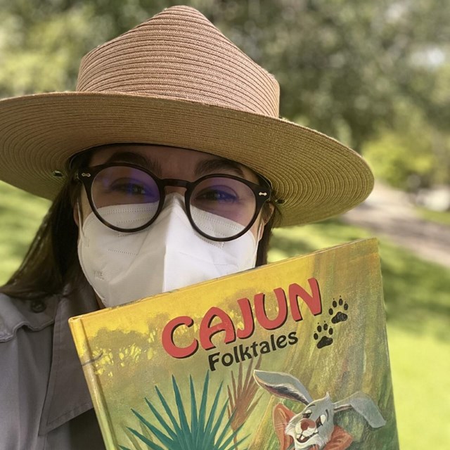 Park ranger holds up a children's book titled 