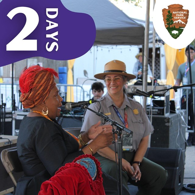 A park ranger and a woman sit on stage in front of microphones. Text 