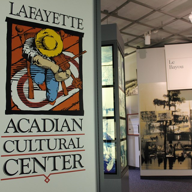 museum entrance sign with exhibit of black and white photos in distance