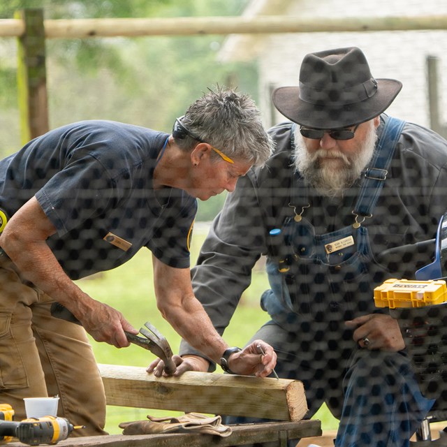 A Park guide and volunteer work inside a chicken coop.