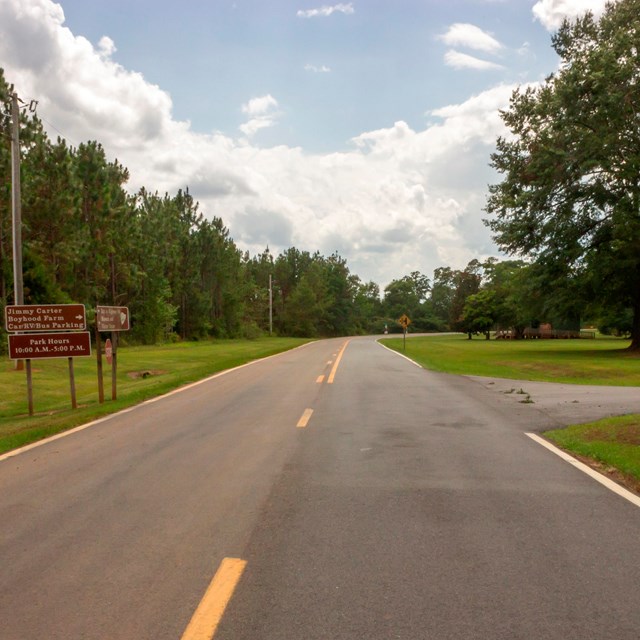 Road signs on either side of a roadway direct drivers.
