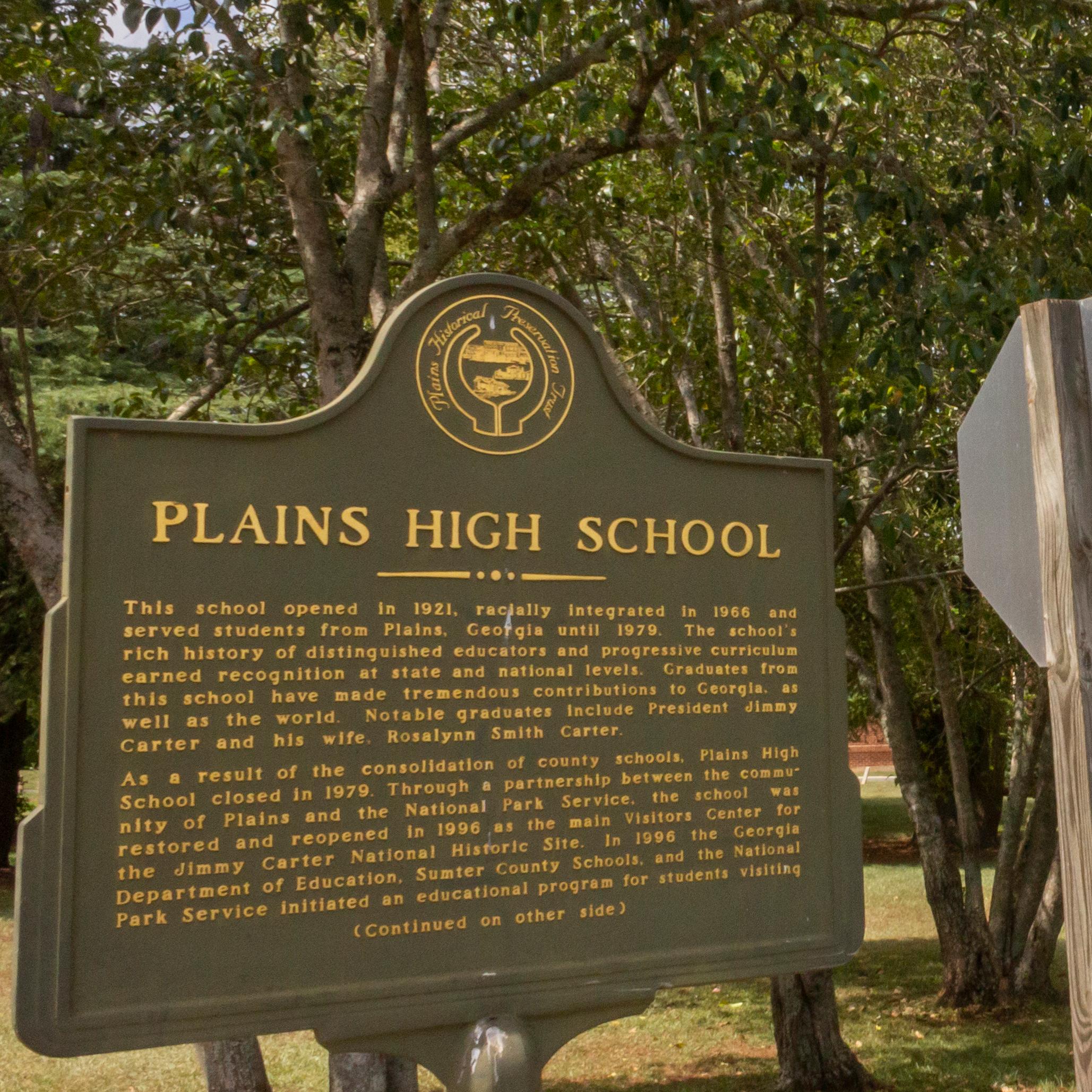 A historic marker stands outside the entrance to Plains High School