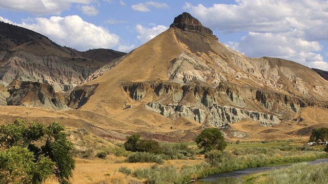 Eroded claystone reveals the past with blue, tan, pink, and brown rock layers.