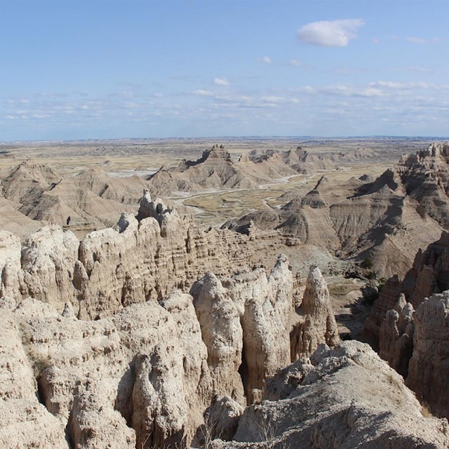 A hilly area where the hills have been eroded into spires and valleys show water paths below.