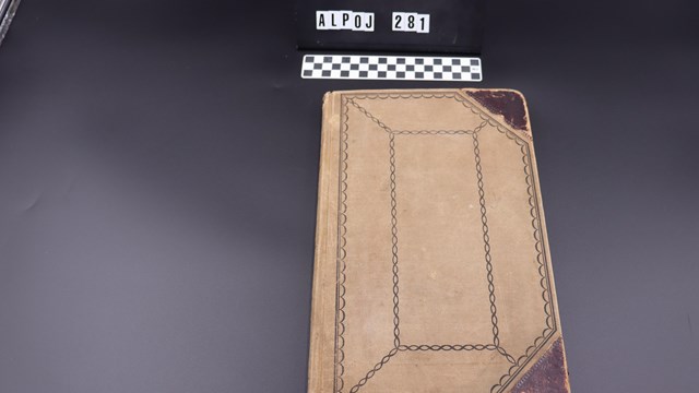 A tan color morgue book to record descriptions of flood victims.
