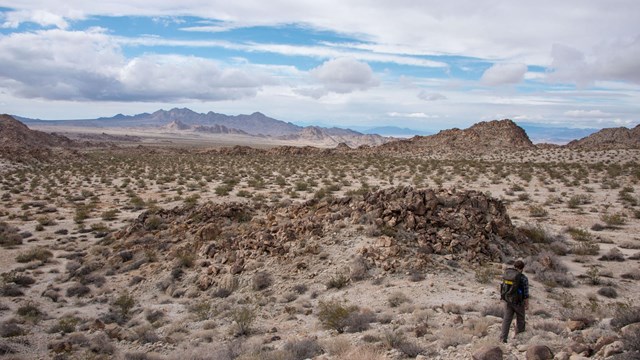 Color photo of a backpacker hiking through the Coxcomb Mountains.