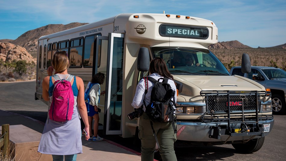 Color photo of visitors boarding the free RoadRunner shuttle bus.