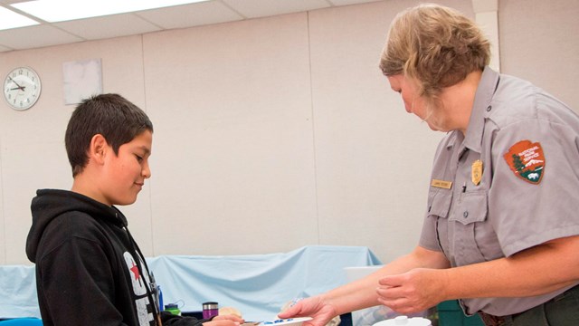 A ranger and student in a classroom setting. 