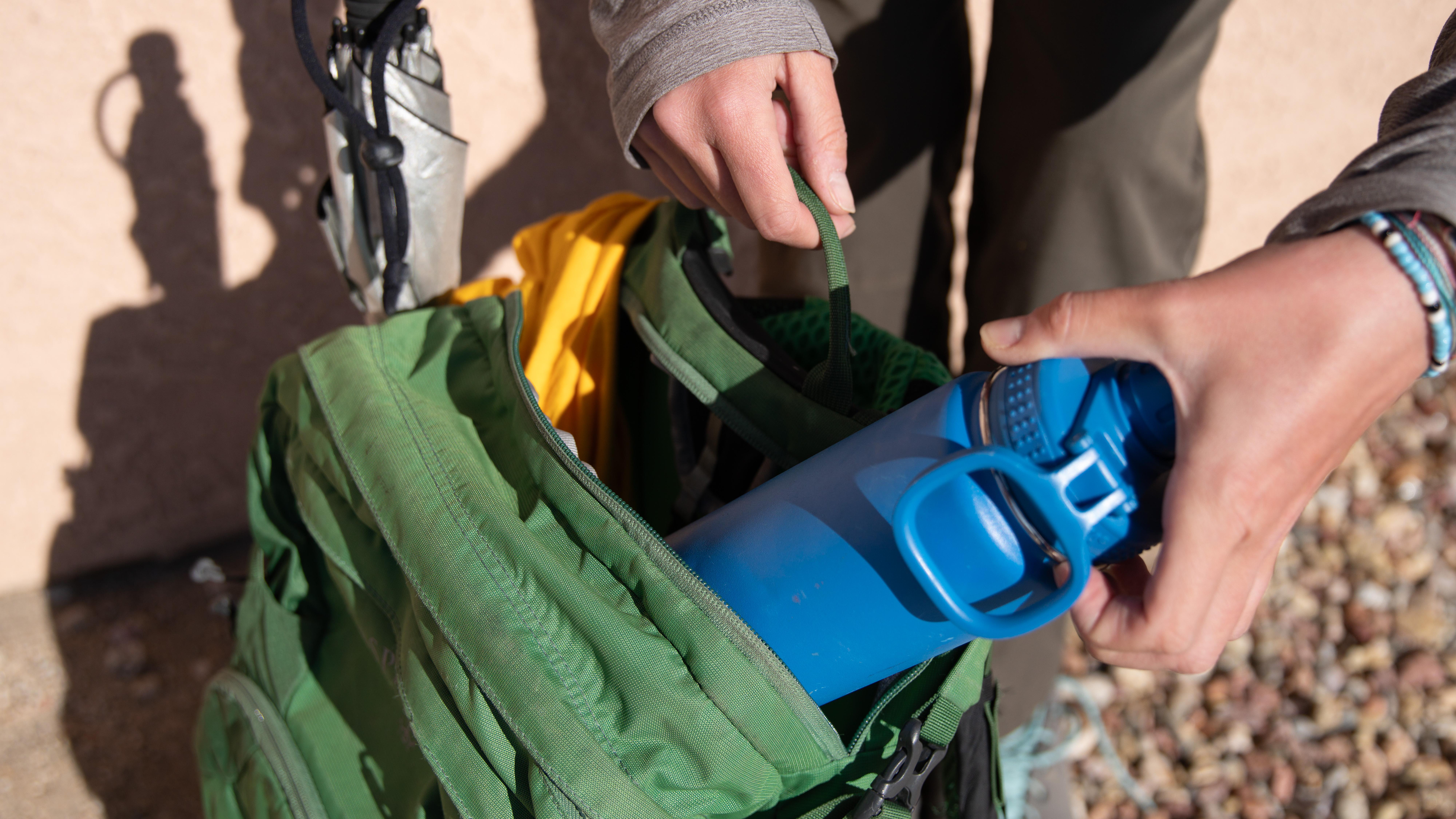 Hand packing items in a backpack