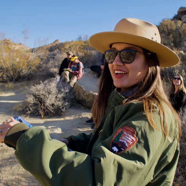 A park ranger smiles at the camera