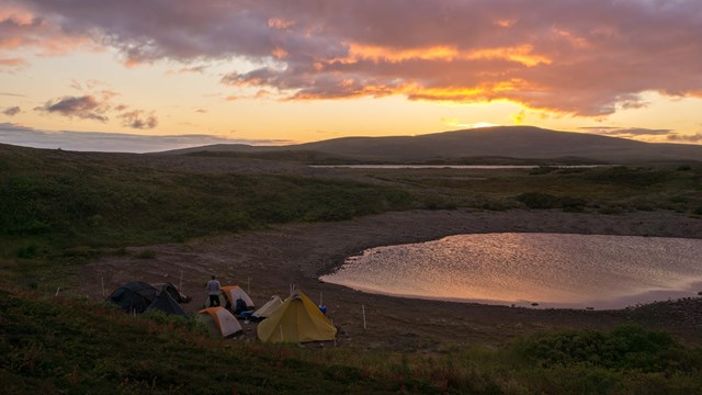 a group of tents bordered by an electric fence in Katmai's backcountry