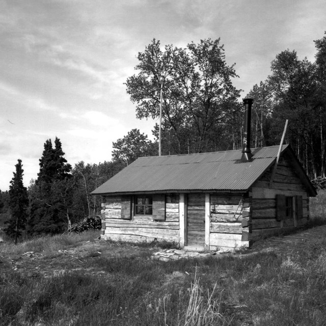 a rustic cabin on a hill above a lake