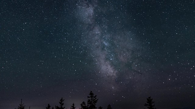 Stars above Katahdin Woods and Waters National Monument. The background is blue with bright stars.