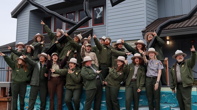 A group of park rangers point in many directions