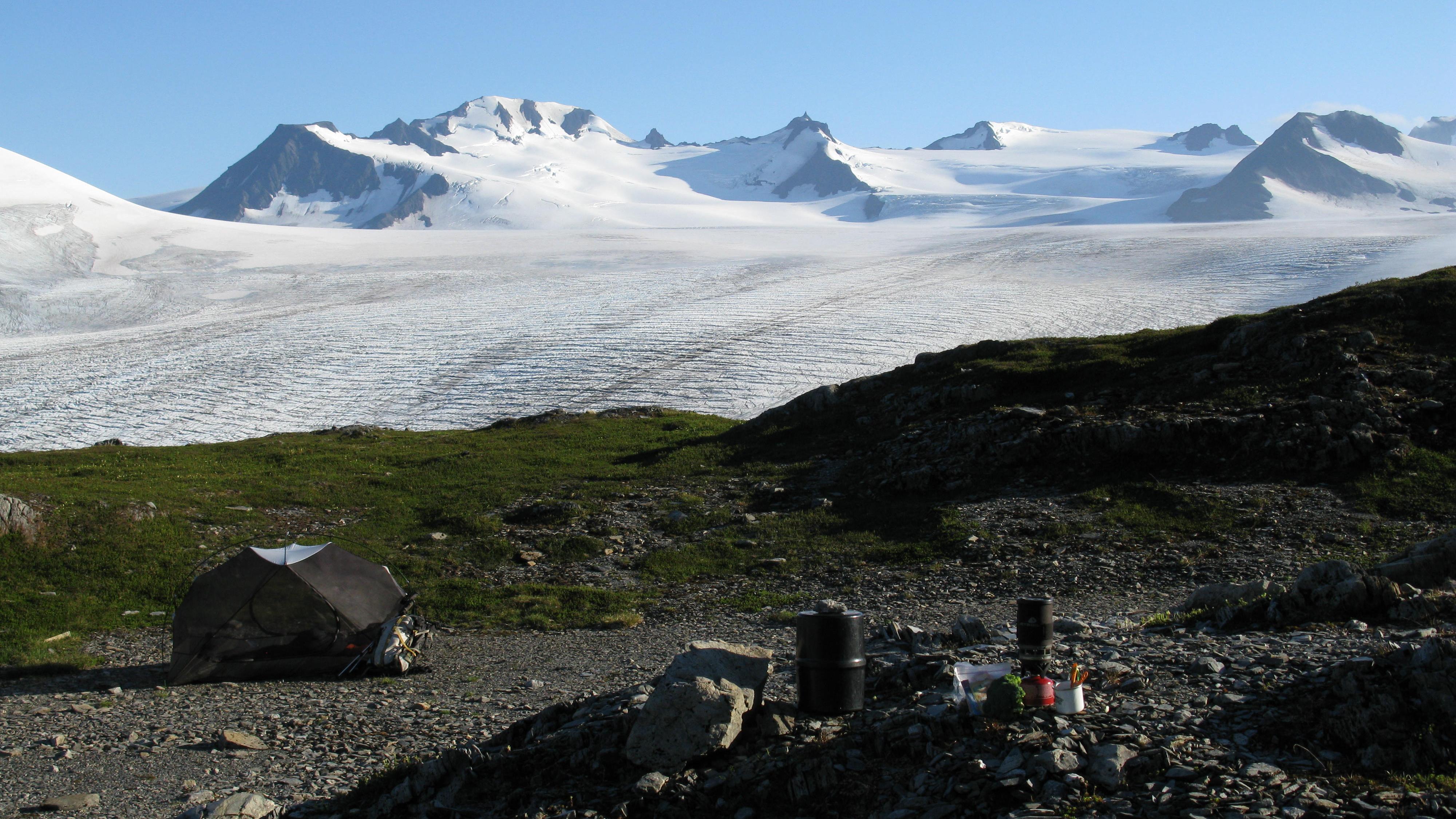 Gear and tent with icefield in the distance