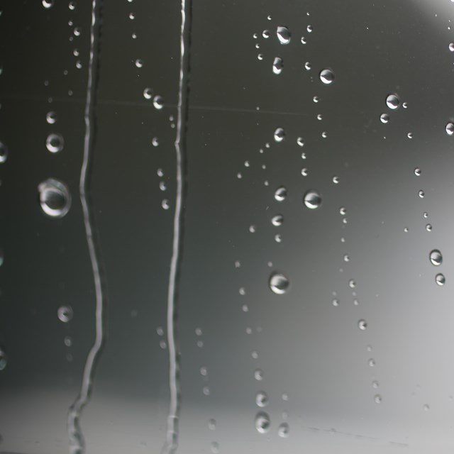 Raindrops bead up on a window.