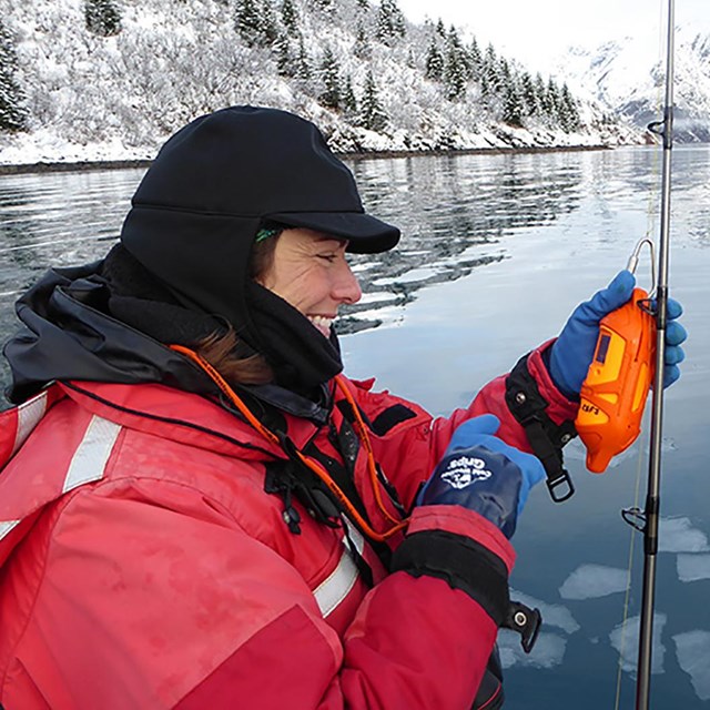 A park researcher using an instrument  test water temperature and salinity