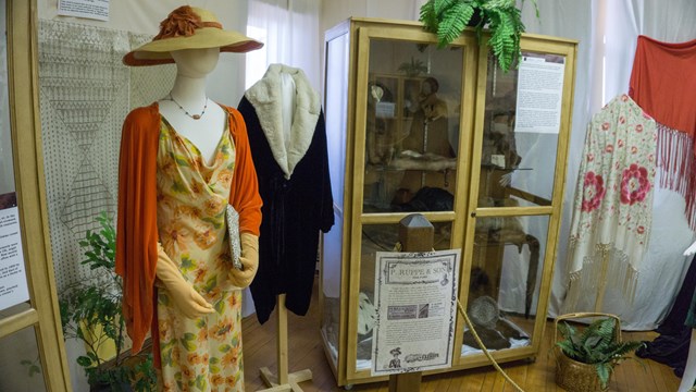 A mannequin with an outfit on next to other clothing items.