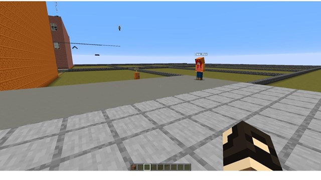 A partially built Minecraft scene shows a street which ends in divided grassy lots