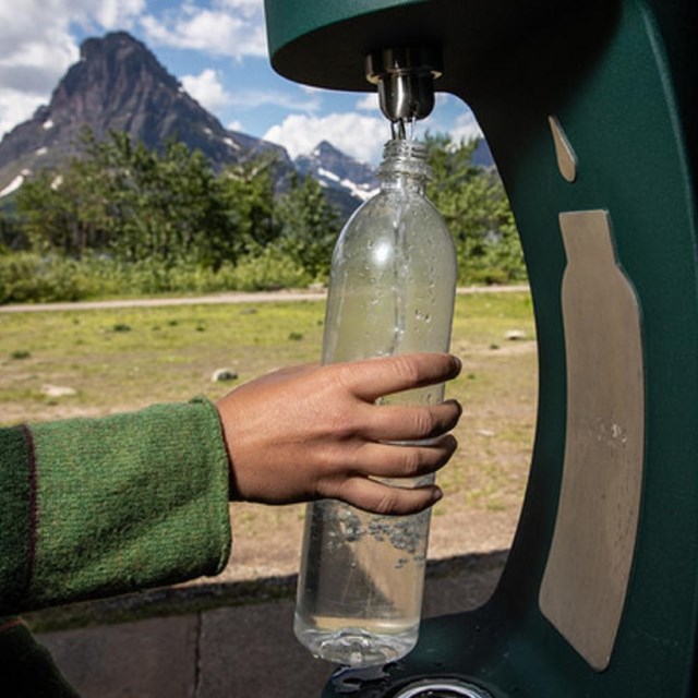 a water bottle filling station is used to refill a water bottle