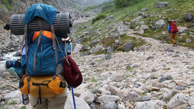 A backpacker hikes on rocky terrain