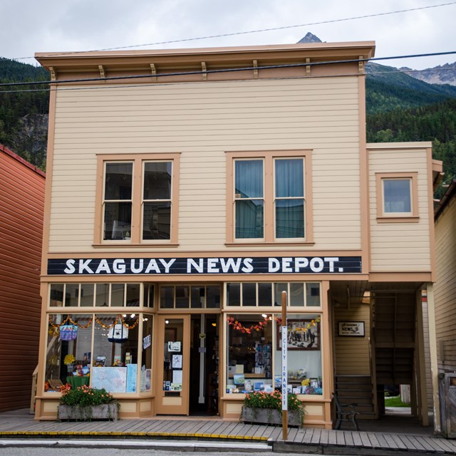 A two story yellow building with sign 