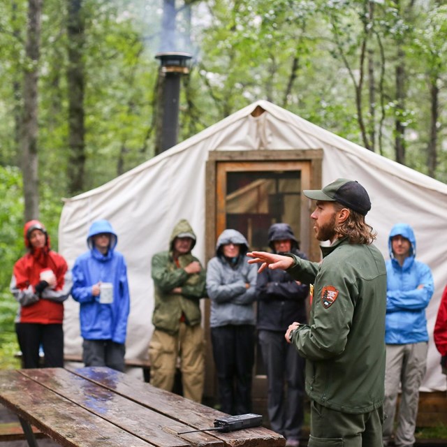 A ranger talks to hikers outside