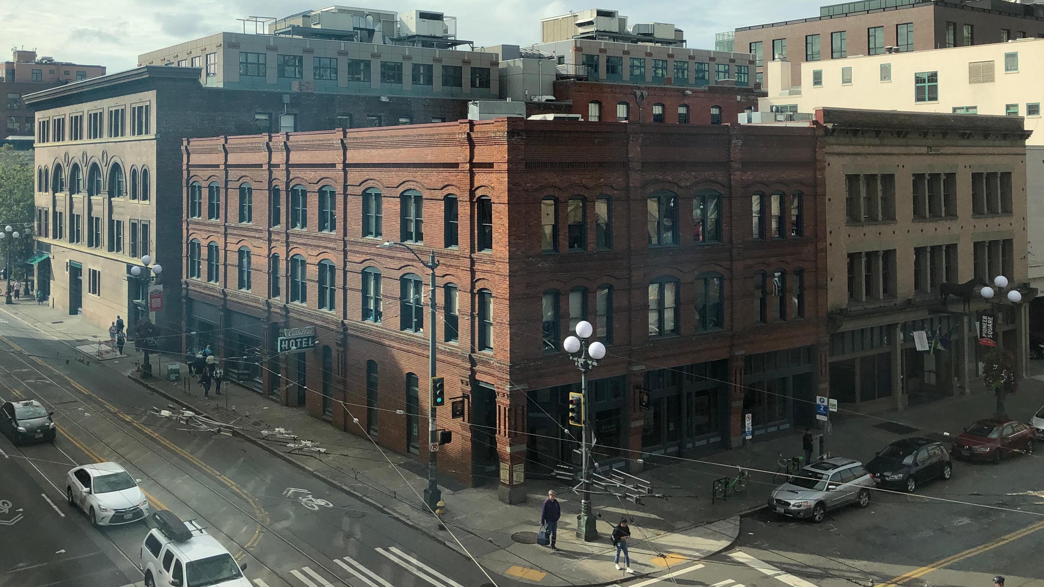 a large brick building on a corner with many windows on both visible sides