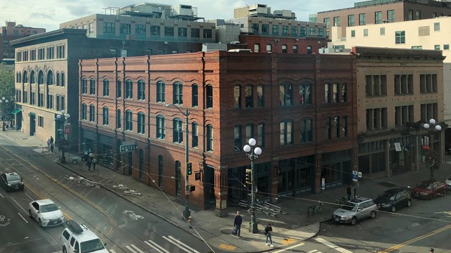 a large brick building on a corner with many windows on both visible sides